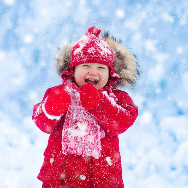 Μωρό που παίζει με το χιόνι το χειμώνα. — Φωτογραφία Αρχείου