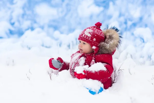 Bébé jouant avec la neige en hiver . — Photo