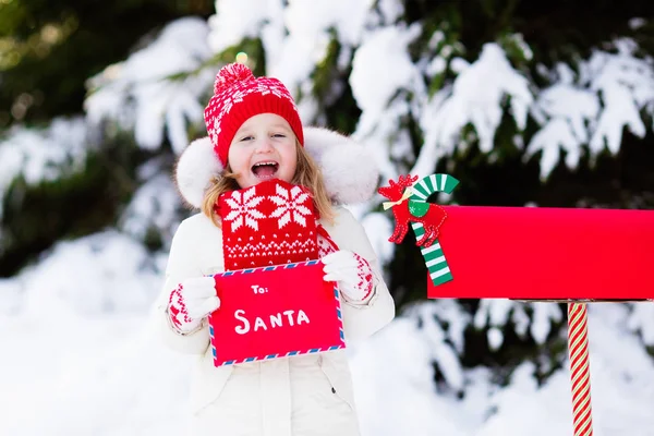 Bambino con lettera a Babbo Natale cassetta postale in neve — Foto Stock