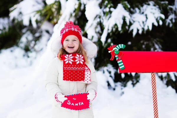 Enfant avec lettre au Père Noël à la boîte aux lettres dans la neige — Photo