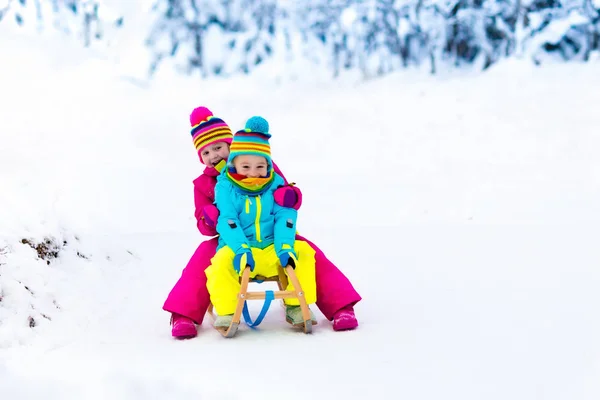 お子様は冬の公園でそりで雪で遊ぶ — ストック写真