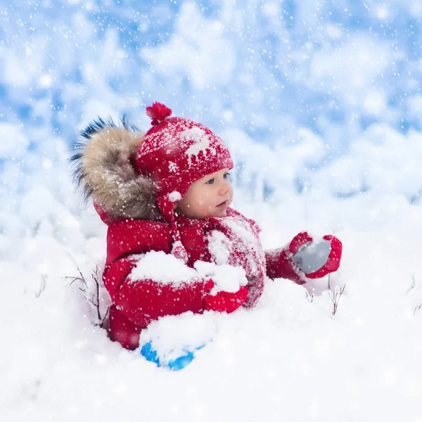 Barnet leker med snö på vintern. — Stockfoto