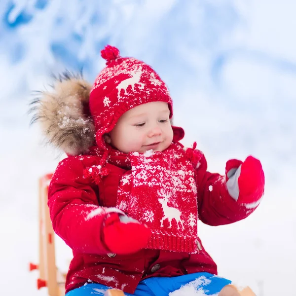 Los niños juegan en la nieve. Paseo en trineo de invierno para niños —  Fotos de Stock