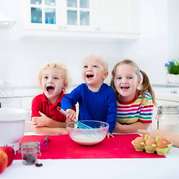 Kids baking a pie in white kitchen — Stock Photo, Image