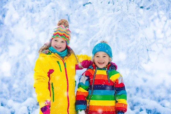 Los niños juegan con nieve en el parque de invierno —  Fotos de Stock