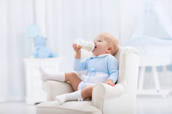 Baby boy with bottle drinking milk or formula