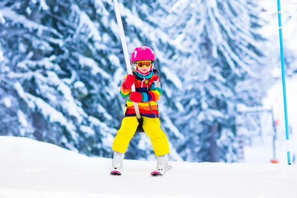 Criança no elevador de esqui na escola de esporte de neve nas montanhas de inverno — Fotografia de Stock