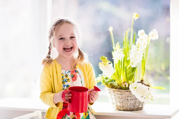 Liten flicka vattning vårblommor — Stockfoto