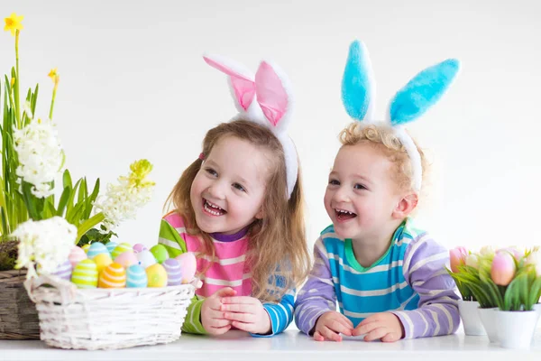 Bambini con orecchie da coniglio a caccia di uova di Pasqua — Foto Stock