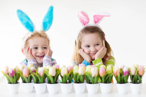 Crianças com orelhas de coelho na caça ao ovo de Páscoa — Fotografia de Stock