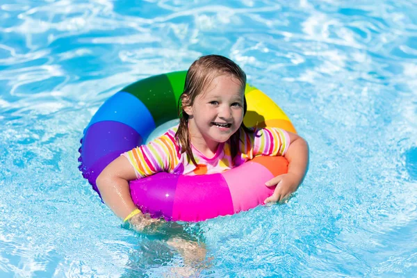 Liten flicka med leksak ring i poolen — Stockfoto