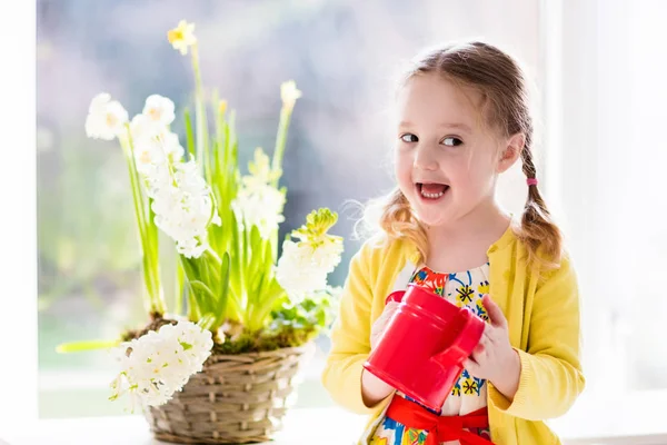 Little girl watering spring flowers — Stock Photo, Image