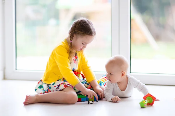 Irmã e irmão bebê brincam com blocos de brinquedo — Fotografia de Stock