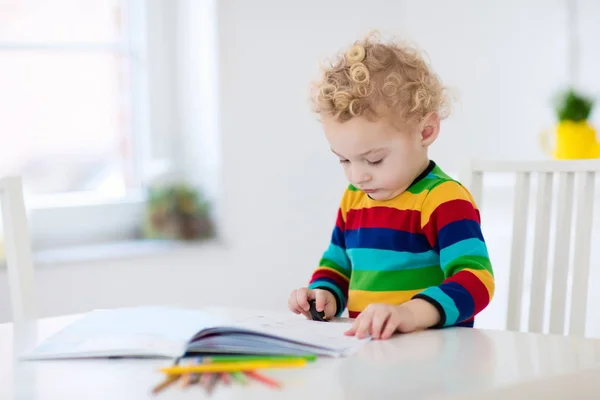 Los niños leen, escriben y pintan. Niño haciendo la tarea . —  Fotos de Stock