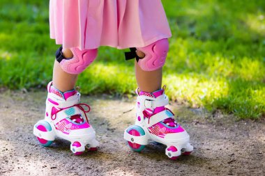 Küçük kız bir parkta paten ayakkabı ile