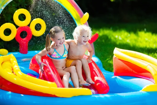 Crianças brincando na piscina inflável — Fotografia de Stock