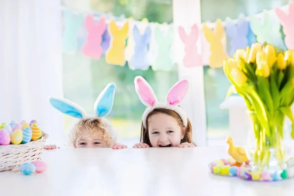 Kinderen met bunny oren op Easter egg hunt — Stockfoto