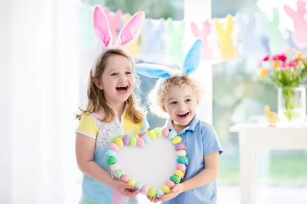 Niños en orejas de conejo en la búsqueda de huevos de Pascua — Foto de Stock