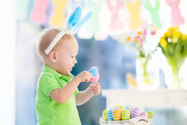 Baby med bunny öron på påskägg jaga — Stockfoto