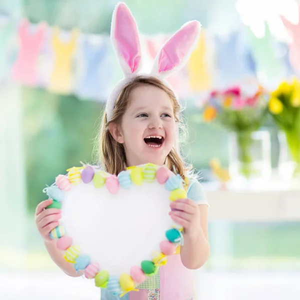 Kleines Mädchen mit Hasenohren auf Ostereiersuche — Stockfoto