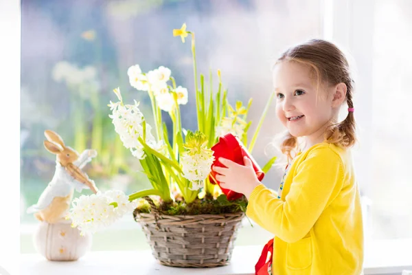 Malá dívka zalévání jarní květiny — Stock fotografie