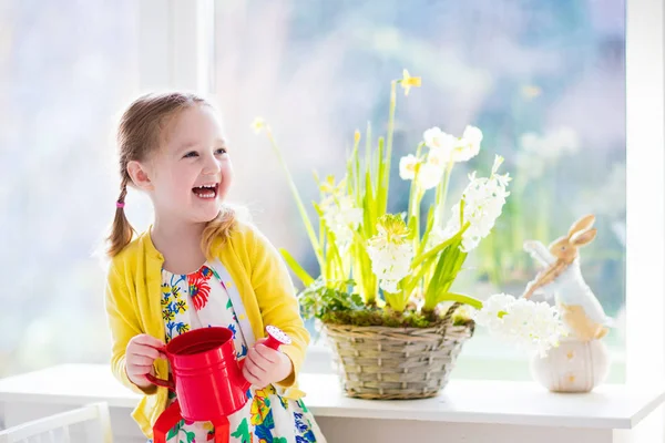 Cute girl watering first spring flowers. — Stock Photo, Image