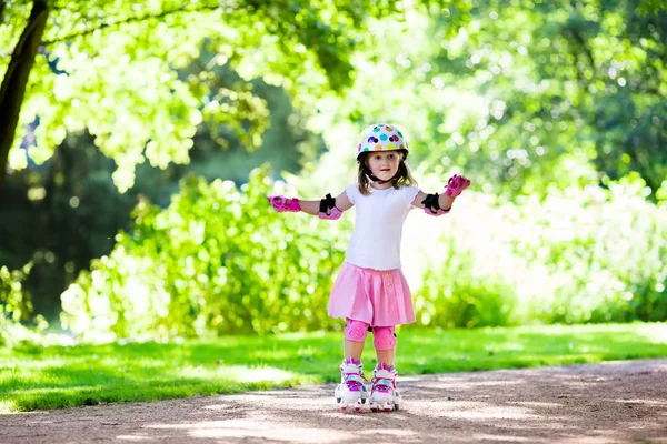 Petite fille avec des chaussures de patin à roulettes dans un parc — Photo