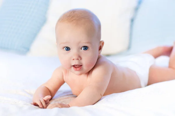 Bébé en couche au lit. Nouveau-né à la maison . — Photo