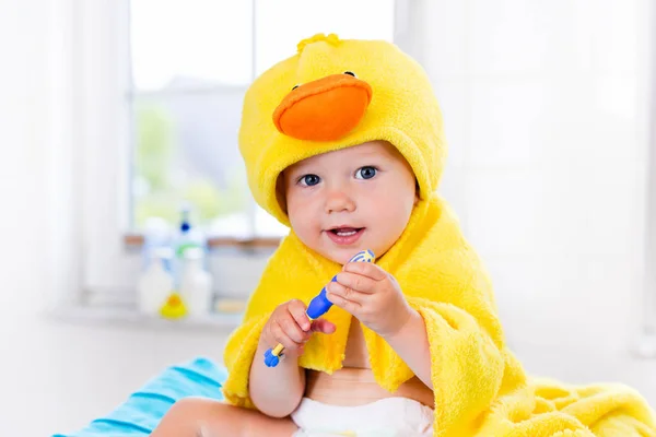 Bebé en toalla de baño con cepillo de dientes —  Fotos de Stock