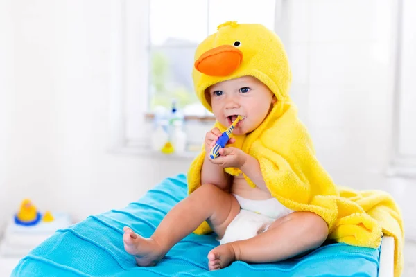 Baby in bath towel with tooth brush — Stock Photo, Image