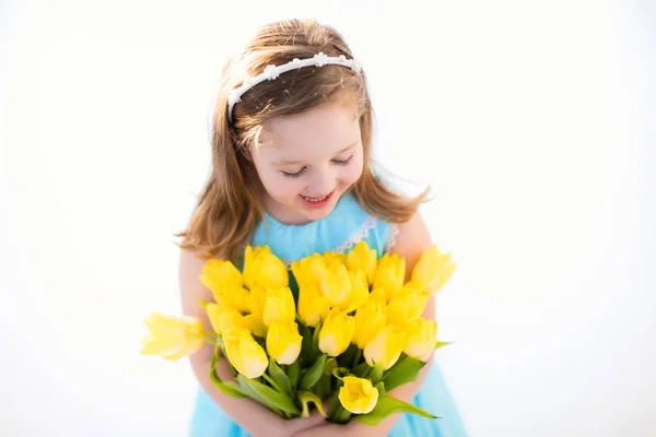 Petite fille avec bouquet de fleurs de tulipe — Photo