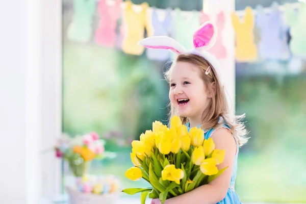 Kleines Mädchen mit Hasenohren auf Ostereiersuche — Stockfoto