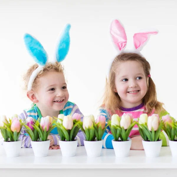 Kinder mit Hasenohren auf Ostereiersuche — Stockfoto