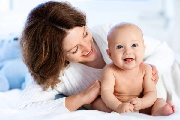 Bebé y madre en casa en la cama. Mamá y el niño . — Foto de Stock