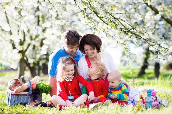 Gezin met kinderen op picknick in lentetuin — Stockfoto
