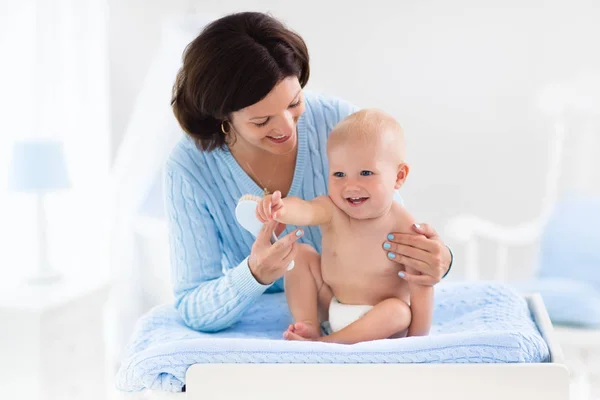 Mother changing diaper to baby boy