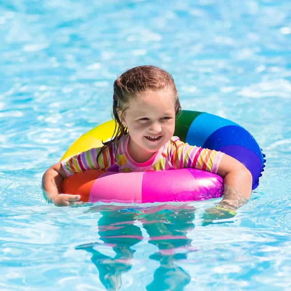 Liten flicka med leksak ring i poolen — Stockfoto