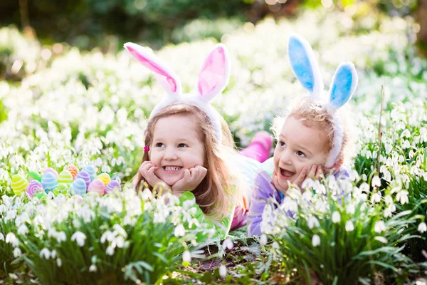 Enfants sur la chasse aux œufs de Pâques dans le jardin de printemps en fleurs — Photo