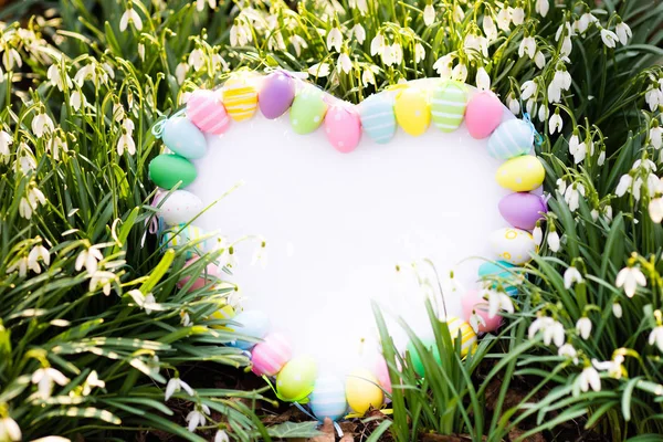 Белая доска с пасхальными яйцами и цветами — стоковое фото