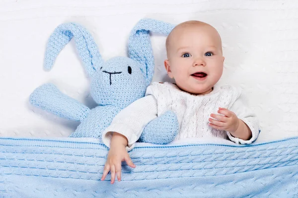 Bayi laki-laki bermain dengan kelinci di tempat tidur — Stok Foto