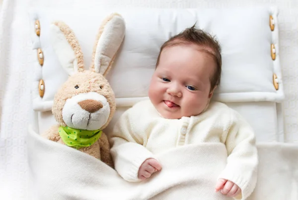 Bebé en la cama con juguete de conejo —  Fotos de Stock