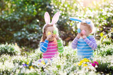 Çocuklar çiçeklenme içinde Paskalya yumurtası avına Bahçe bahar