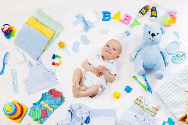 Baby with clothing and infant care items — Stock Photo, Image
