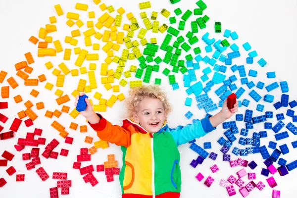 Child playing with rainbow plastic blocks toy — Stock Photo, Image