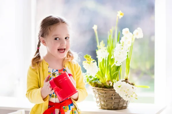 Liten flicka vattning vårblommor — Stockfoto