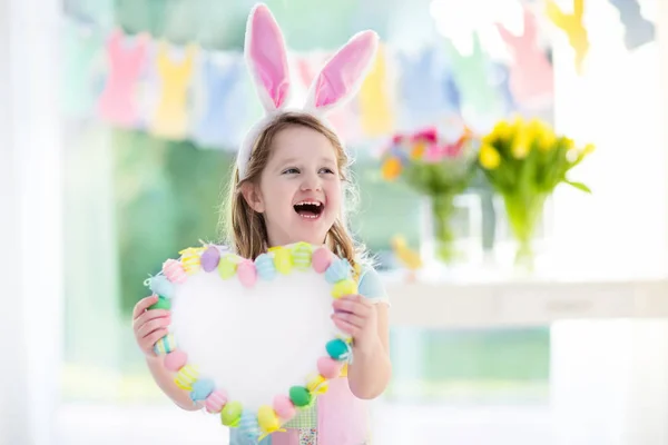 Niña en orejas de conejo en la búsqueda de huevos de Pascua — Foto de Stock