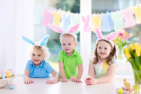 Enfants avec des oreilles de lapin sur la chasse aux œufs de Pâques — Photo