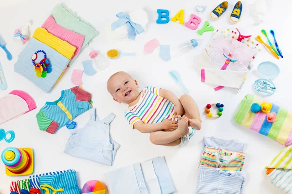 Bebê com roupas e itens de cuidados infantis — Fotografia de Stock