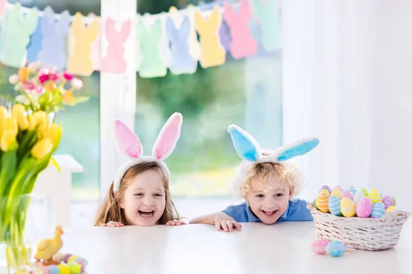 Діти з вухами кролика на полюванні на великодні яйця — стокове фото