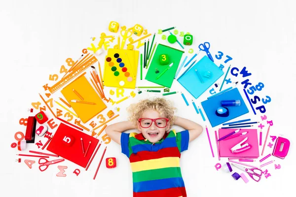 Bambino con scuola e materiale da disegno. Studente con libro . — Foto Stock